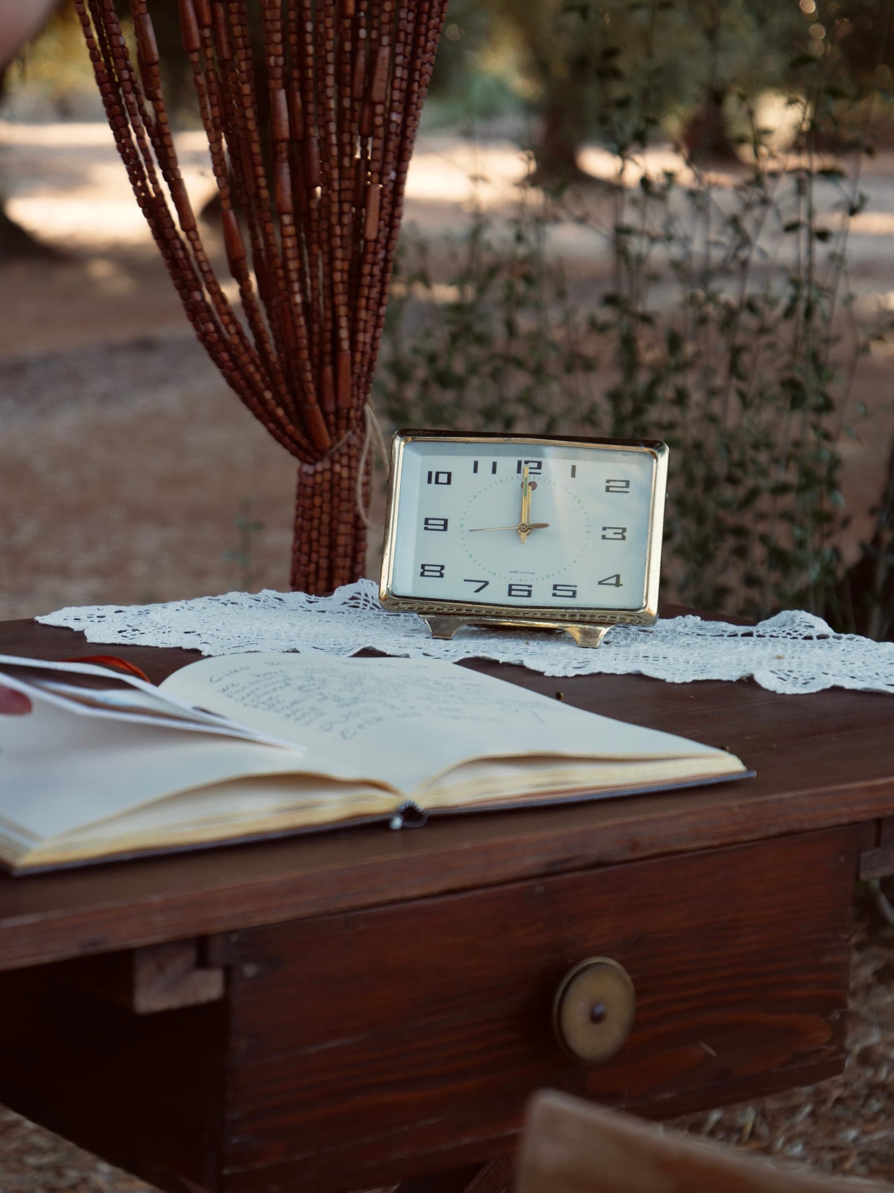 Dettaglio del tavolo con libro aperto e orologio vintage